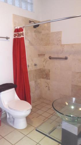 チャカラにあるHotel Casa Chacalaのバスルーム(トイレ、赤いシャワーカーテン付)