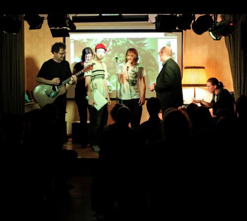 a group of people standing in front of a stage at Hostel die Wohngemeinschaft in Cologne