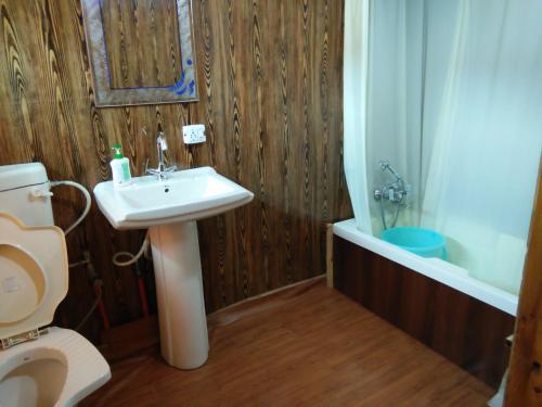 a bathroom with a sink and a toilet and a tub at Tashkand Houseboat in Srinagar