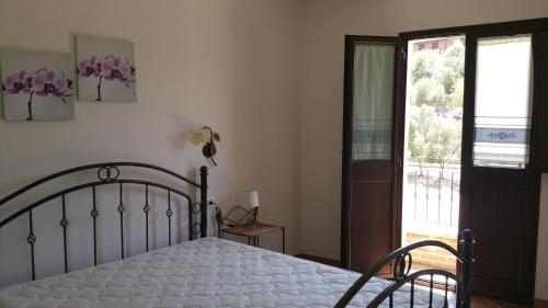 ヴィッラシミーウスにあるAppartamento Isabellaのベッドルーム1室(ベッド1台付)、スライド式ガラスドアが備わります。