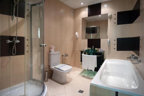 a bathroom with a toilet and a shower and a sink at Hotel Primorsko Del Sol in Primorsko