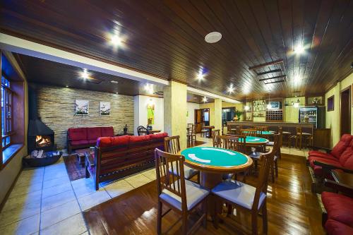 a restaurant with tables and chairs and a fireplace at Pousada dos Pinhos in Pedra Azul