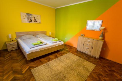 a bedroom with a bed and an orange and green wall at Apartment Bright & Light in Ljubljana