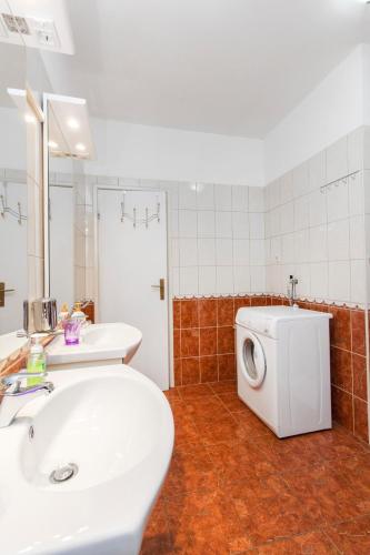 a bathroom with a sink and a washing machine at Vila Jadranka in Vodice