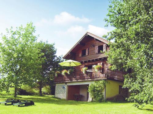 Holzhaus mit Balkon und Sonnenschirm in der Unterkunft Cozy Chalet with Breathtaking Views in Hommert in Hommert