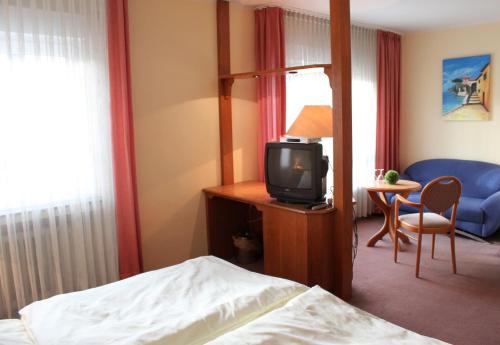 a hotel room with a bed and a tv at Hotel Niederée in Bad Breisig