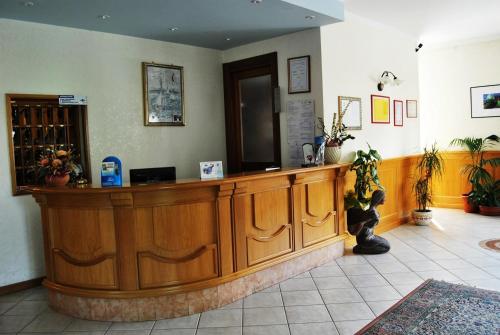 a wooden reception counter in a room with plants at Albergo Genzianella in Fiavè