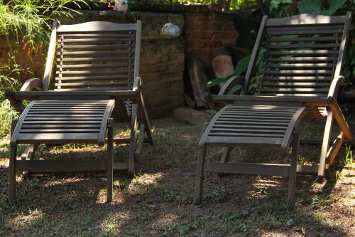 two chairs sitting next to each other in the grass at Pousada Do Ó in Tiradentes