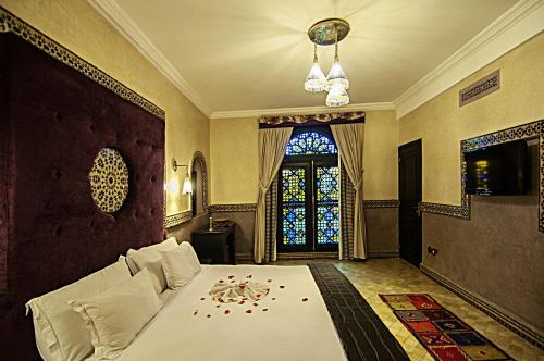a bedroom with a large bed with a window at Palais Ommeyad Suites & Spa in Fès