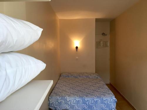 Habitación pequeña con cama y almohadas en Hôtel du Centre, en París