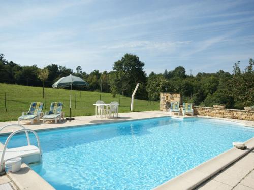 - une piscine avec des chaises et un parasol dans l'établissement Stone house with private pool, à Villefranche-du-Périgord