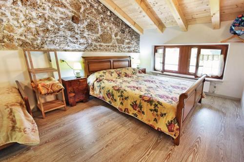 una camera con letto e pavimento in legno di Albergo Diffuso "Col Gentile" Socchieve a Priuso
