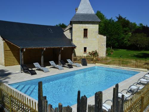 a swimming pool with chairs and a building at Cozy Holiday Home in Brion with Swimming Pool in Brion