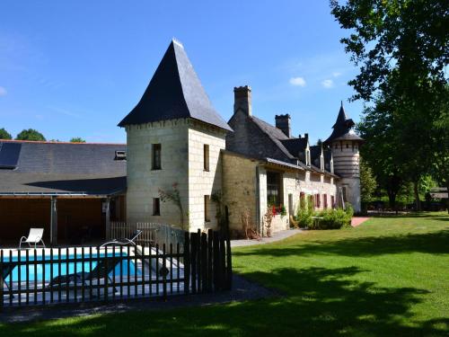un vieux château avec une clôture devant lui dans l'établissement Holiday Home in Brion with Pool and Nature, à Brion