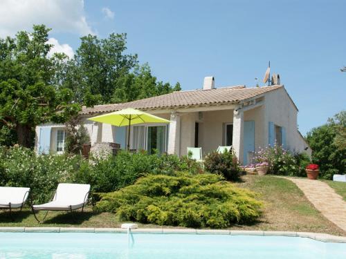 a house with a yellow umbrella and a swimming pool at Rustic villa with pool in Cereste France in Céreste