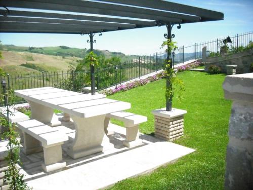 a picnic bench under a pergola in a yard at Belvilla by OYO Graceful Apartment with Garden in Petrella Guidi