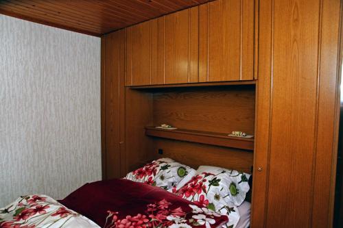 - une chambre avec un lit et une armoire en bois dans l'établissement S.C.I. Rannerbaach, à Dirbach