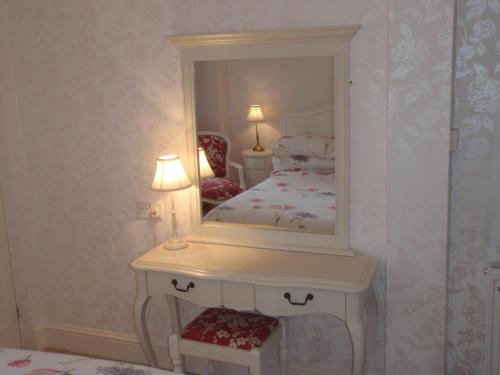 a bedroom with a bed with a large mirror at Barnes Fell Apartments in Ambleside