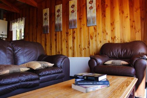 a living room with two leather couches and a coffee table at Cabañas & Piscina Rucamalen in Ensenada