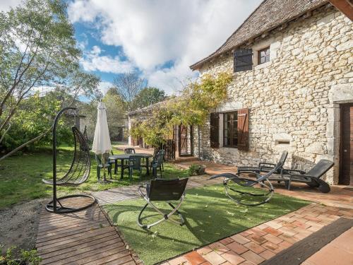 un patio con sillas, una mesa y una sombrilla en Charming holiday home with pool, en Monbazillac