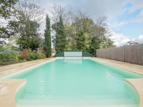 a swimming pool in a backyard with a fence at Charming holiday home with pool in Monbazillac