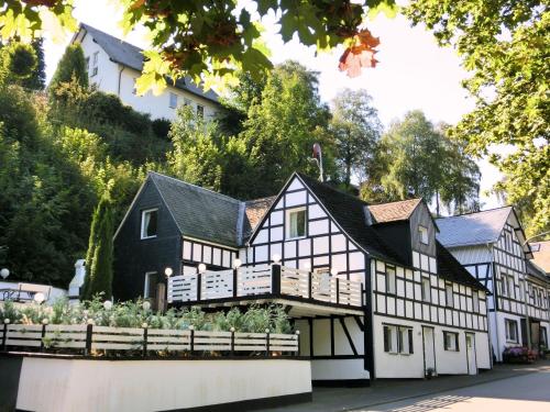 a black and white house with a garden in front of it at Charming holiday home near the ski area in Schmallenberg