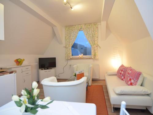 a living room with a white couch and a window at Charming holiday home near the ski area in Schmallenberg
