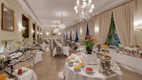 a dining room with white tables and chairs with food at Hotel Europäischer Hof Heidelberg, Bestes Hotel Deutschlands in historischer Architektur in Heidelberg