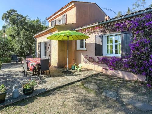 a patio with a table and an umbrella at Boutique Holiday Home in Bormes les Mimosas with Pool in Bormes-les-Mimosas