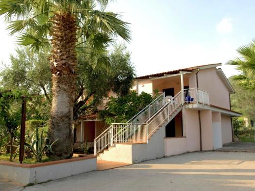 チェントラにあるHoliday Home in Palinuro with Pool Terrace Garden Bicyclesの階段のある建物の隣のヤシの木