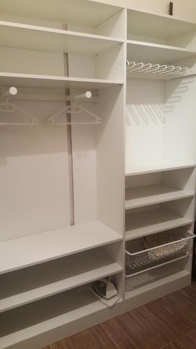 a white closet with white shelves at Orsi's sweet & lovely home in Budapest