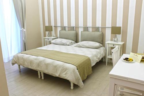 ein Schlafzimmer mit einem Bett mit zwei Tischen und zwei Lampen in der Unterkunft La Maison in Vallata