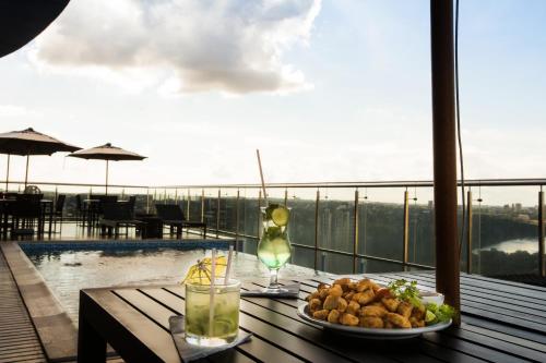 a table with a plate of food and a glass of wine at Viale Tower Hotel in Foz do Iguaçu