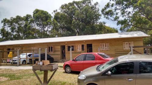 ein Holzgebäude mit davor geparkt in der Unterkunft Residencial Maia in Capão da Canoa