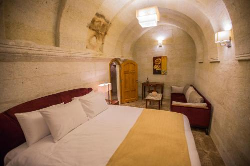 a bedroom with a bed and a couch in a room at Agarta Cave Hotel in Goreme