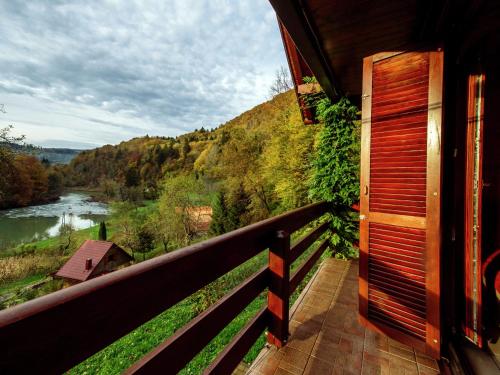 een balkon van een huis met uitzicht op een rivier bij Serene holiday home in Dolu with private garden in Brod Moravice
