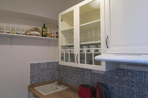 - une cuisine avec des placards blancs et un évier dans l'établissement Apartments near Lesser Town, à Prague