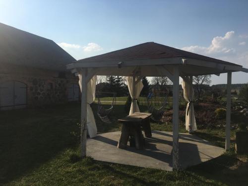 a picnic shelter with a bench in a yard at Placówka - tu życie płynie wolniej in Wydminy