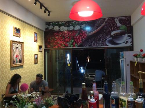 a man and woman sitting at a table in a restaurant at Amaretto Hostel in Surat Thani