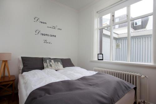 ein Schlafzimmer mit einem Bett mit Worten an der Wand in der Unterkunft Aska Apartment in Reykjavík