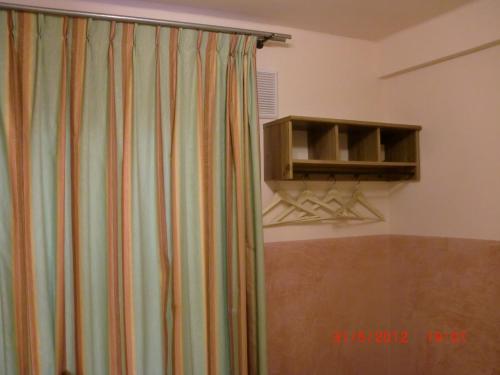 a shower curtain in a room with a shelf at Budget Hotel Neutraal in Amsterdam