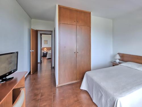 a bedroom with a bed and a television and a hallway at Dom Pedro Portobelo in Vilamoura