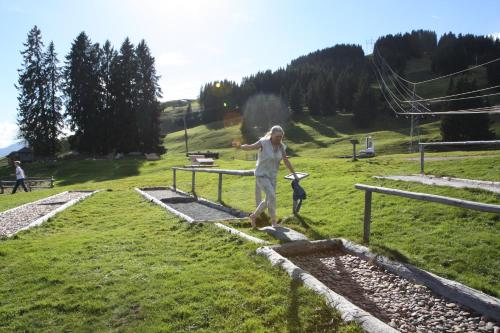 a woman throwing a frisbee in a field at Ferienwohnung Gabriele in Brixen im Thale