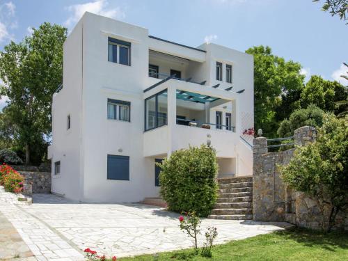 a white house with a stone wall at Modish Villa in Lefkogia Crete with Swimming Pool in Lefkogeia