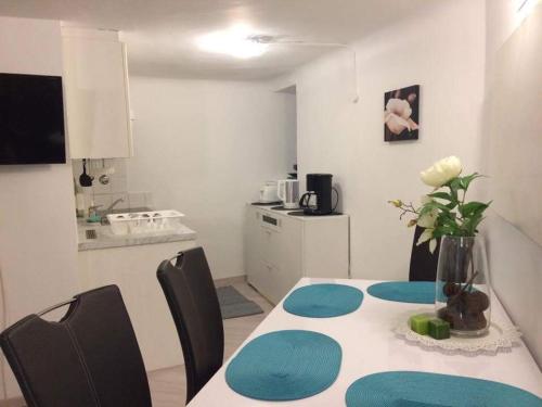 a kitchen with a table with a vase of flowers on it at Gemütliche 4 Zimmer Whg in der Residenz Elisabeth in Bad Ischl