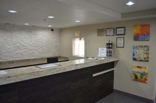 a waiting room with a counter and paintings on the wall at Super 8 by Wyndham Irving/DFW Apt/North in Irving