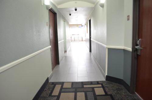 an empty hallway with a door and a tile floor at Super 8 by Wyndham Irving/DFW Apt/North in Irving