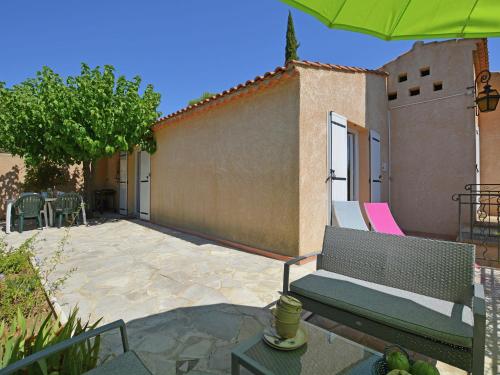a patio with a bench and a table and an umbrella at Spacious holiday home with private pool in Saint-Maximin