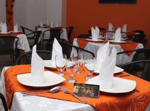 una mesa con platos blancos y copas de vino. en Hotel Bogota Astral, en Bogotá