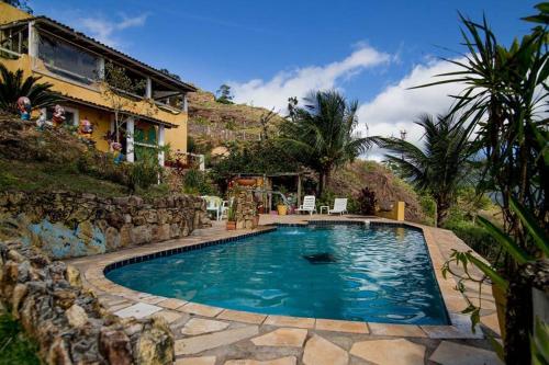 a swimming pool in front of a house at Vila Lia in São Sebastião